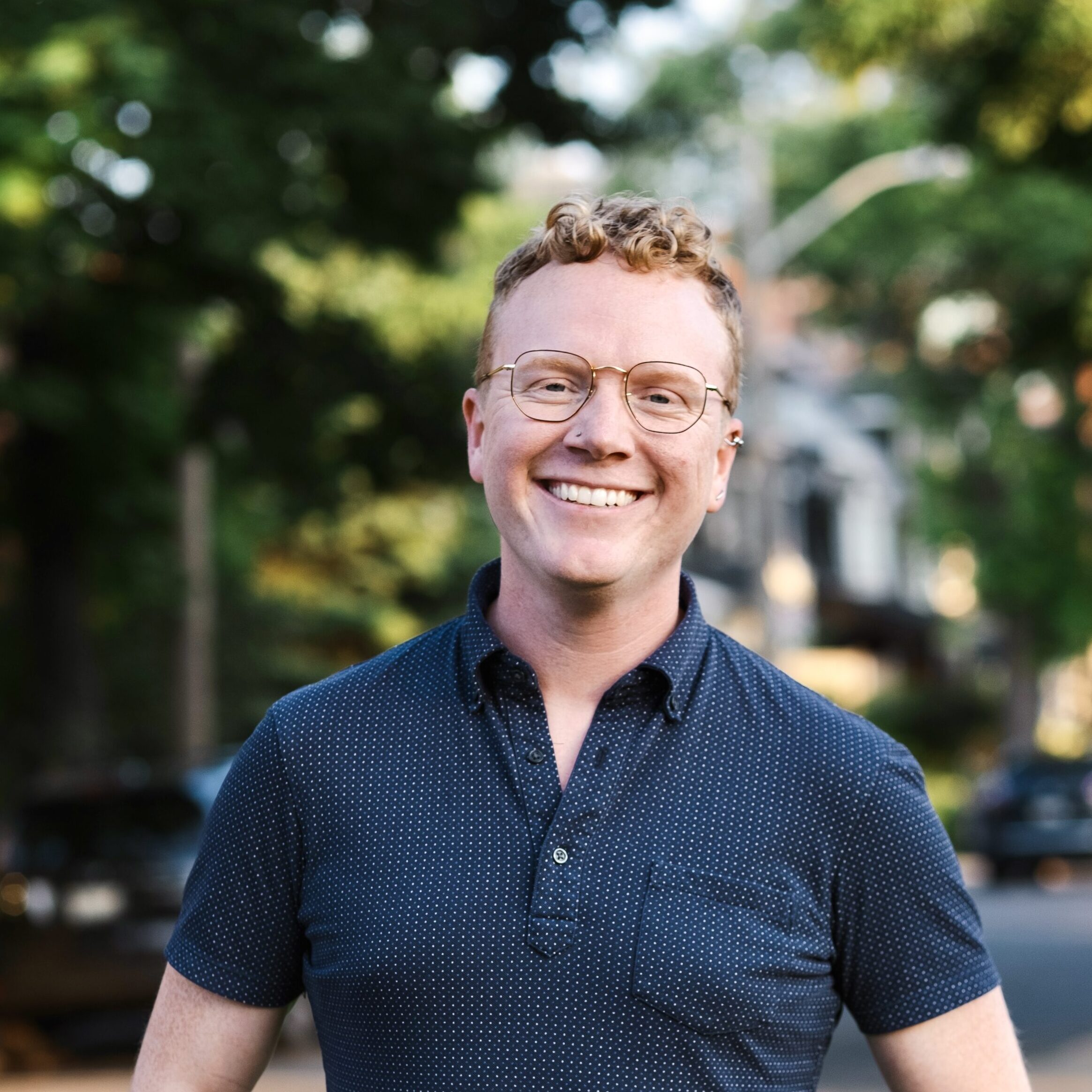 Une photo du Dr Alex Wells souriant dans une rue ensoleillée.