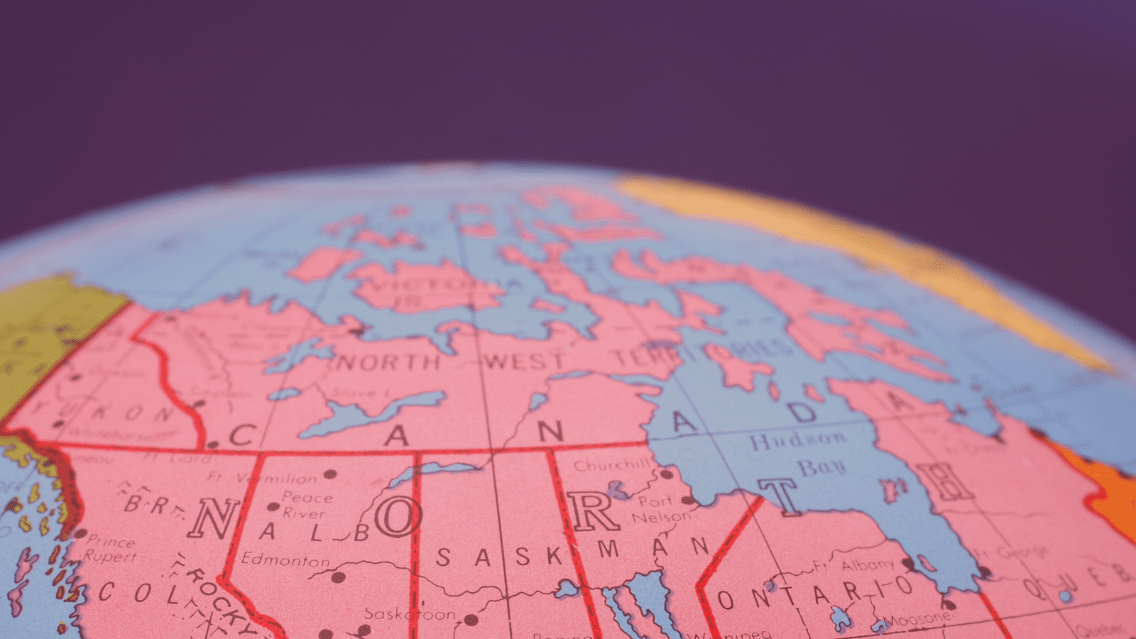 A globe showing the map of Canada, filtered red, with a graphic of an arrow superimposed above it, pointing eastward.