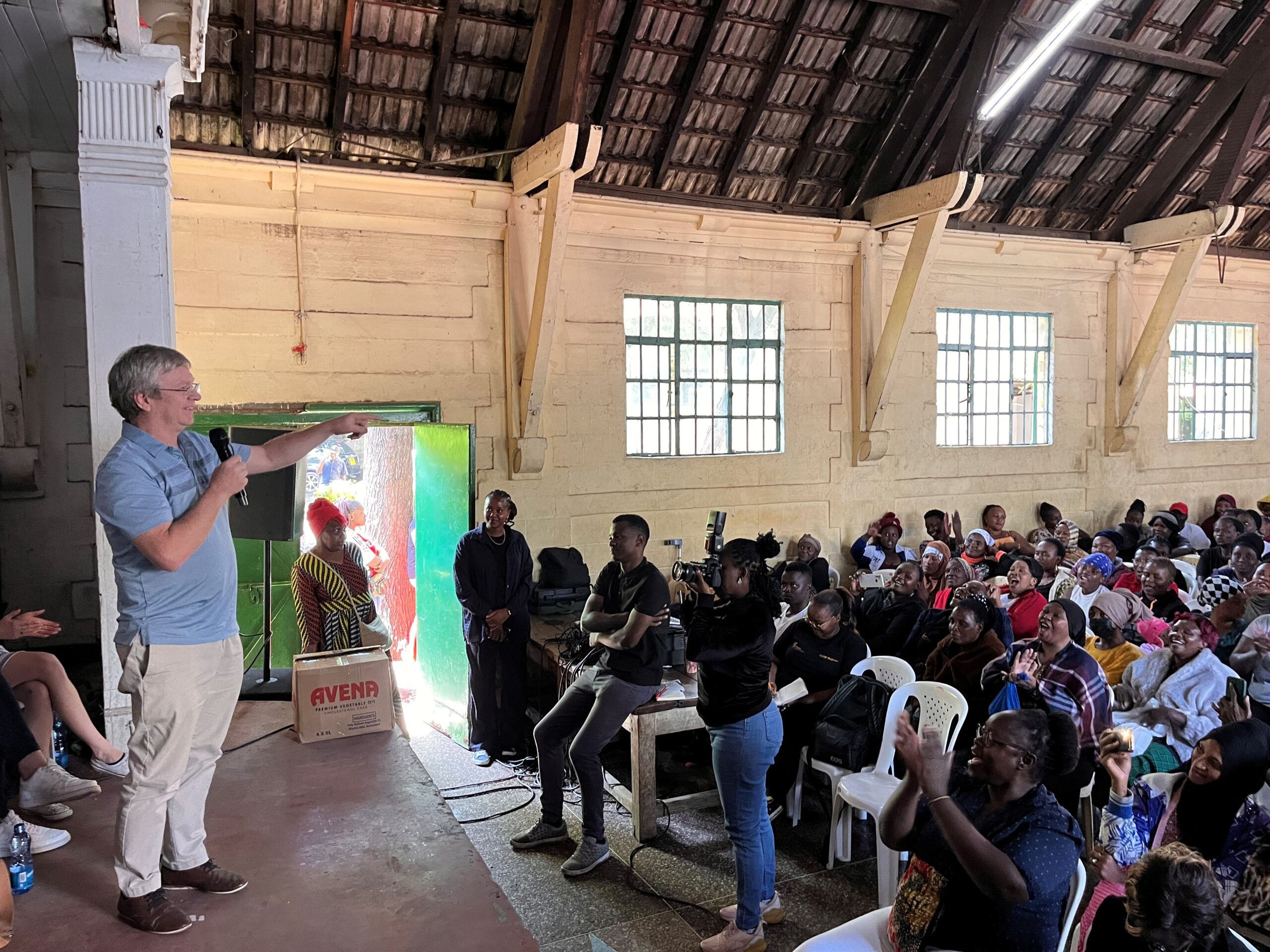 Dr. Keith Fowke speaking to an auditorium of community members in Kenya. 